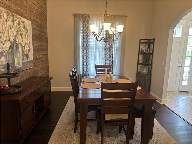 2875 Creeks Crossing Blvd, Lakeland, FL 33810 - dining area featuring wood walls, dark wood finished floors, arched walkways, a notable chandelier, and baseboards