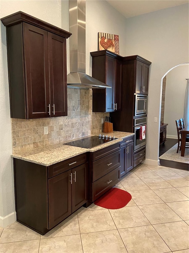 2875 Creeks Crossing Blvd, Lakeland, FL 33810 - kitchen with dark brown cabinets, wall chimney exhaust hood, arched walkways, appliances with stainless steel finishes, and tasteful backsplash