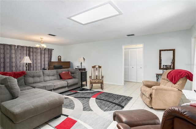 tiled living room featuring a chandelier and a textured ceiling