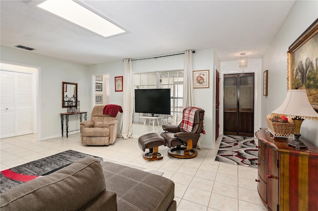 living room with light tile patterned flooring and a textured ceiling