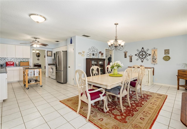 tiled dining room featuring ceiling fan with notable chandelier and a textured ceiling