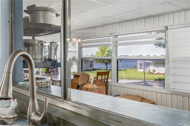 sunroom featuring a drop ceiling and a water view