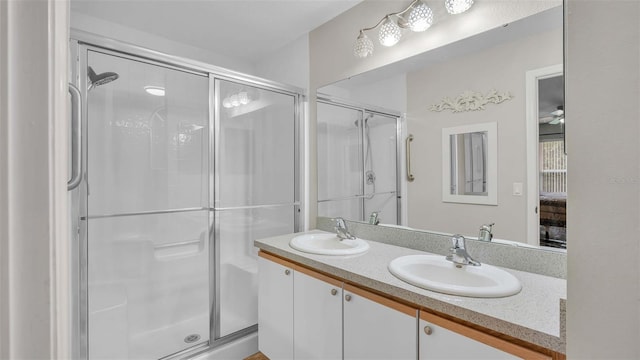 bathroom with ceiling fan, vanity, and a shower with shower door