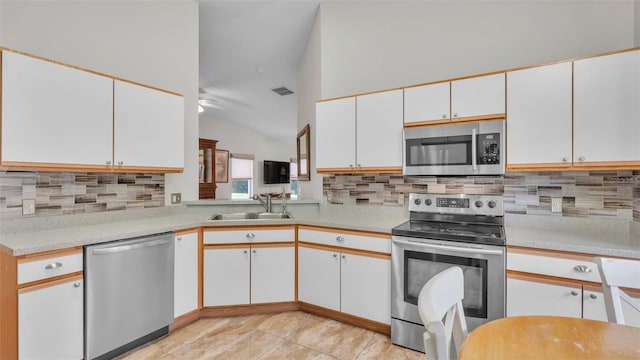 kitchen featuring appliances with stainless steel finishes, ceiling fan, sink, white cabinetry, and lofted ceiling