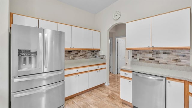 kitchen featuring white cabinets, appliances with stainless steel finishes, and tasteful backsplash