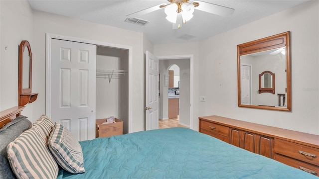 bedroom featuring ceiling fan, a textured ceiling, and a closet