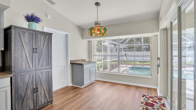 dining room with wood-type flooring and vaulted ceiling