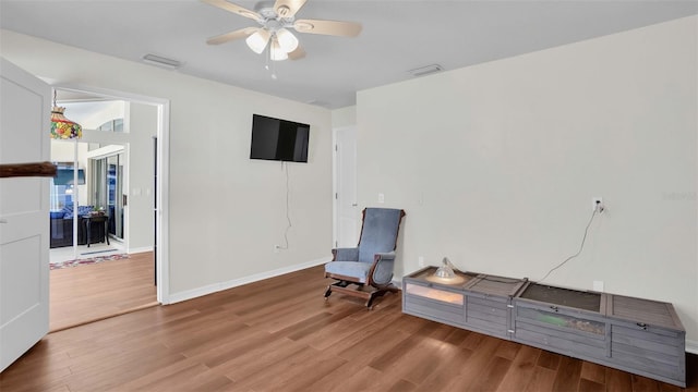 living area with hardwood / wood-style flooring and ceiling fan