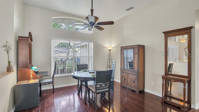 dining space featuring a high ceiling, dark hardwood / wood-style floors, and ceiling fan