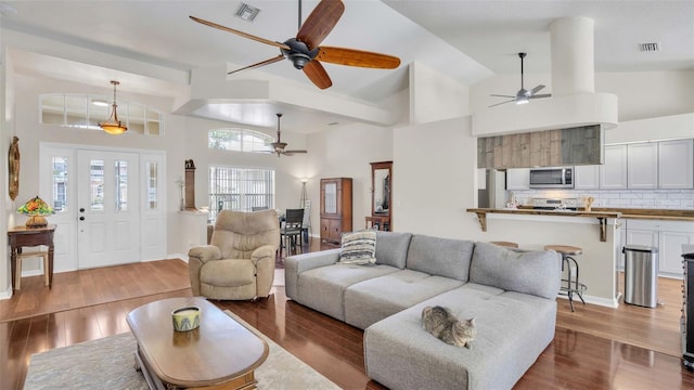 living room with high vaulted ceiling and light hardwood / wood-style floors