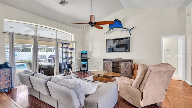 living room with dark wood-type flooring, ceiling fan, and vaulted ceiling