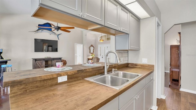 kitchen featuring butcher block countertops, sink, hardwood / wood-style flooring, and ceiling fan