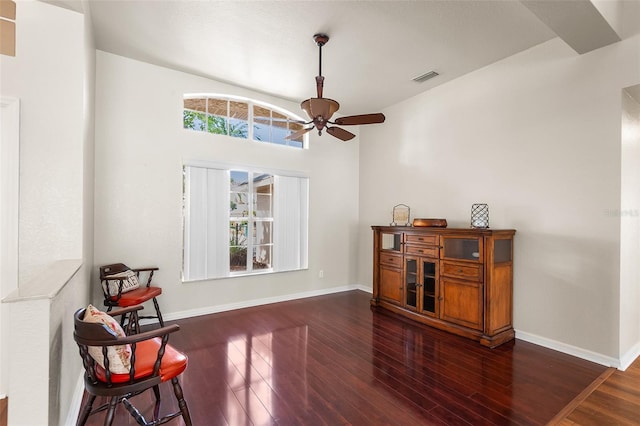 living area featuring visible vents, wood finished floors, baseboards, and ceiling fan