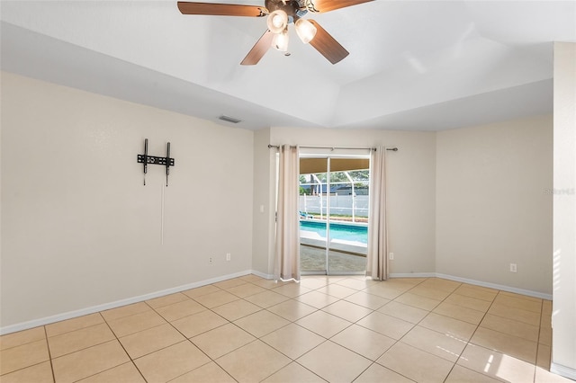 tiled spare room featuring visible vents, baseboards, lofted ceiling, and ceiling fan