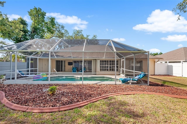back of property featuring a patio area, a fenced in pool, a fenced backyard, and a lanai