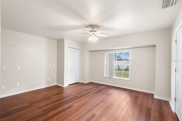 unfurnished bedroom featuring baseboards, ceiling fan, visible vents, and wood finished floors