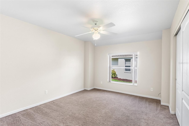 unfurnished bedroom featuring carpet flooring, a closet, baseboards, and a ceiling fan