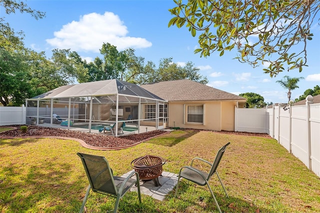 23338 Duchess Ave, Port Charlotte, FL 33954 - back of house with a fenced backyard, an outdoor fire pit, glass enclosure, stucco siding, and a patio
