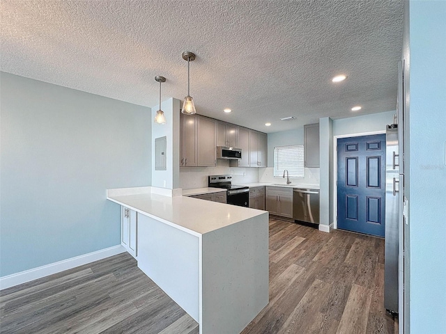 kitchen featuring decorative light fixtures, dark wood-type flooring, gray cabinetry, sink, and appliances with stainless steel finishes