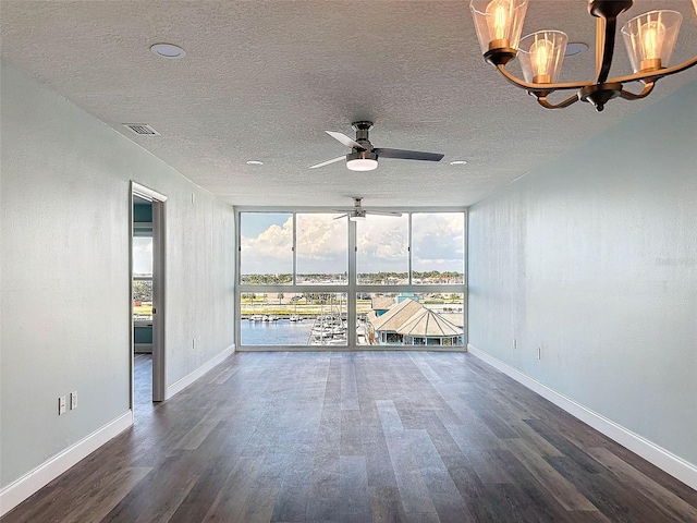 unfurnished room featuring dark hardwood / wood-style floors, ceiling fan with notable chandelier, a textured ceiling, and a wall of windows