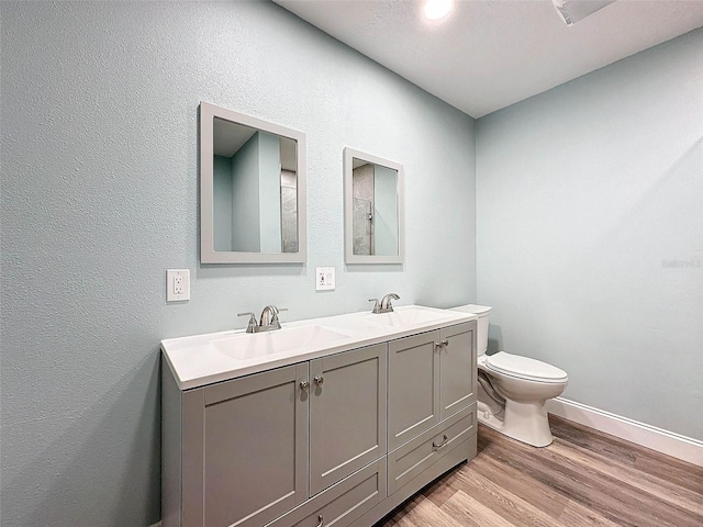 bathroom featuring double vanity, toilet, and hardwood / wood-style flooring