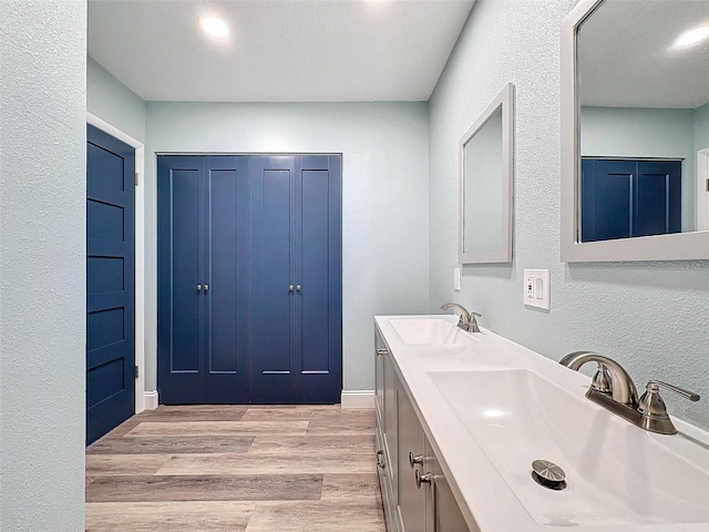 bathroom featuring wood-type flooring, double sink, and oversized vanity