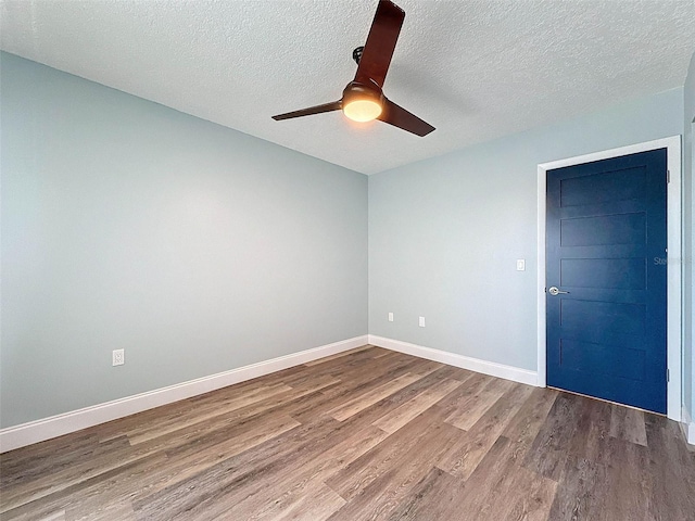 unfurnished room featuring ceiling fan, hardwood / wood-style flooring, and a textured ceiling