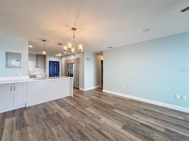 kitchen featuring a notable chandelier, hanging light fixtures, dark wood-type flooring, and a textured ceiling