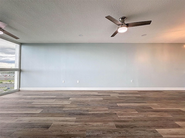 unfurnished room featuring floor to ceiling windows, a textured ceiling, ceiling fan, and dark hardwood / wood-style flooring