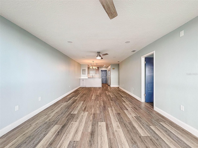 unfurnished living room with a textured ceiling, wood-type flooring, and ceiling fan