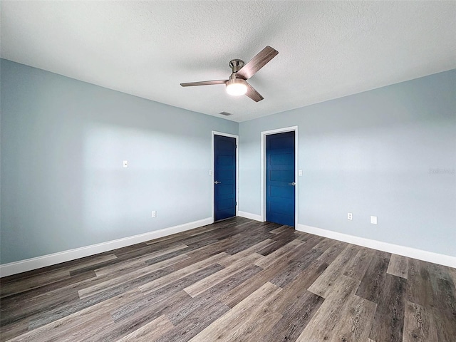 empty room featuring a textured ceiling, ceiling fan, and dark hardwood / wood-style flooring