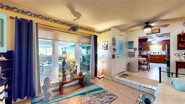 tiled entrance foyer featuring a textured ceiling and ceiling fan