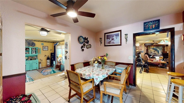 tiled dining space featuring ceiling fan