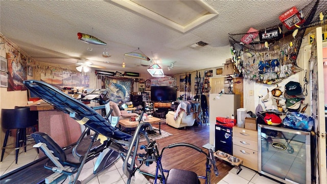 miscellaneous room with ceiling fan, light tile patterned floors, and a textured ceiling