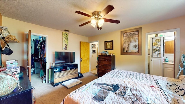 bedroom with carpet flooring, ensuite bath, ceiling fan, a spacious closet, and a closet