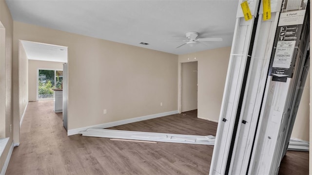 spare room featuring ceiling fan, a baseboard heating unit, and light hardwood / wood-style floors