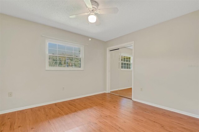 empty room featuring a textured ceiling, ceiling fan, and light hardwood / wood-style floors