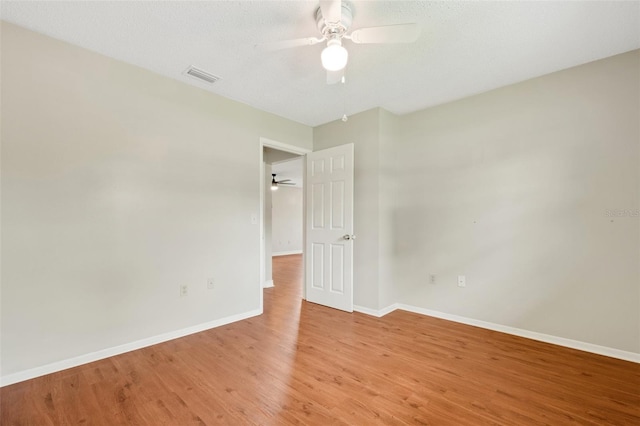 spare room with a textured ceiling, ceiling fan, and light wood-type flooring