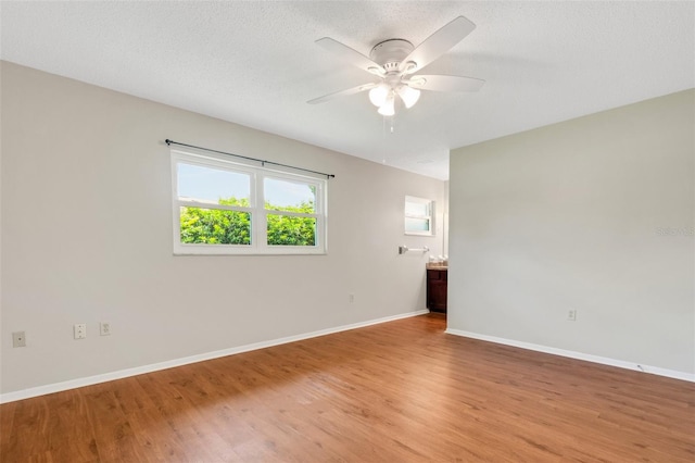 empty room with a textured ceiling, hardwood / wood-style floors, and ceiling fan