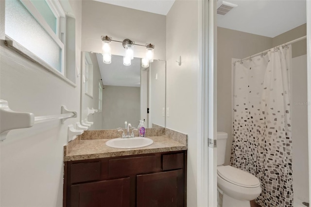 bathroom featuring a shower with shower curtain, toilet, and vanity