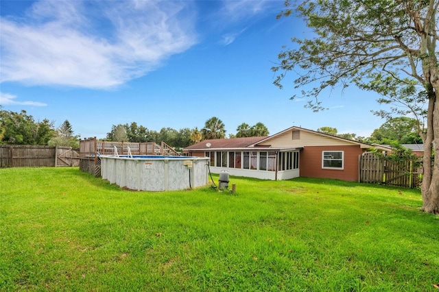 view of yard with a fenced in pool and a sunroom