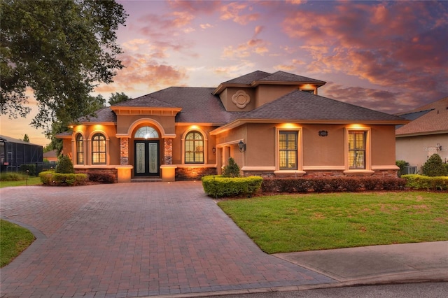 view of front facade with a yard and french doors