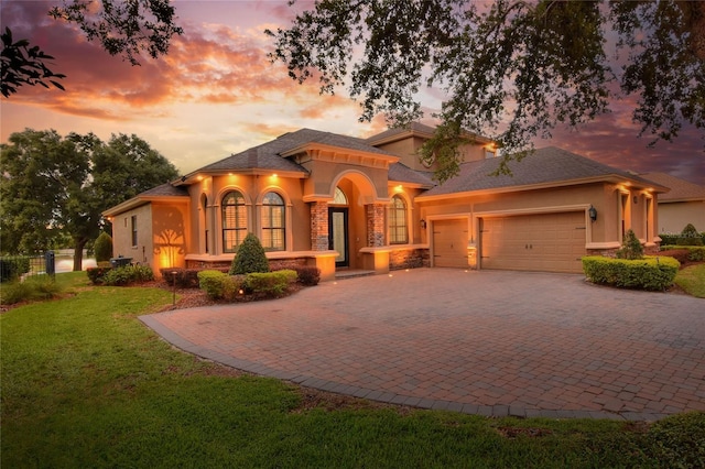 mediterranean / spanish-style home with a garage and a lawn