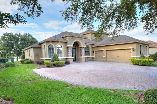 mediterranean / spanish-style house featuring a garage and a front yard