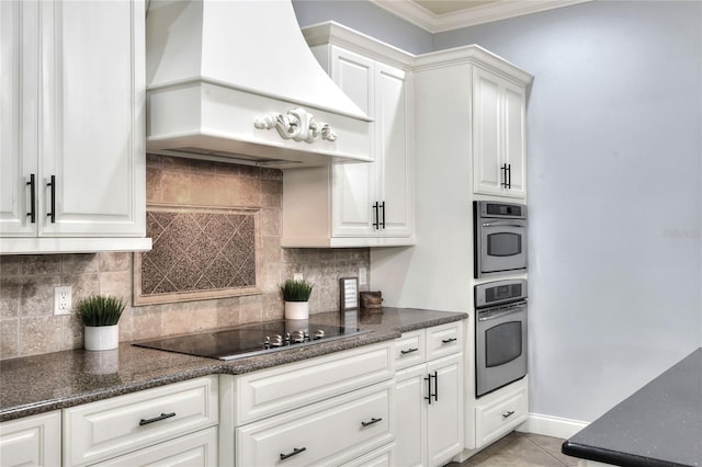 kitchen with premium range hood, black electric stovetop, white cabinets, and light tile patterned flooring