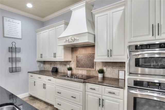 kitchen featuring black electric stovetop, custom range hood, stainless steel double oven, crown molding, and white cabinets