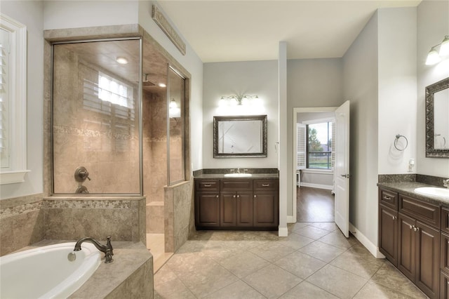 bathroom with tile patterned floors, vanity, and shower with separate bathtub