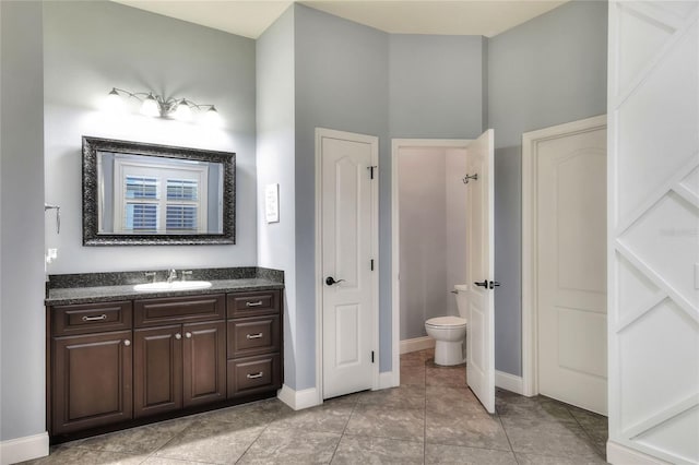 bathroom with tile patterned flooring, vanity, and toilet