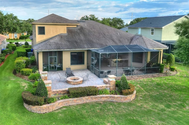 back of property with a lanai, an outdoor fire pit, a patio area, and a lawn