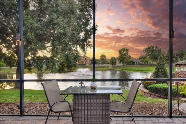 unfurnished sunroom featuring a water view